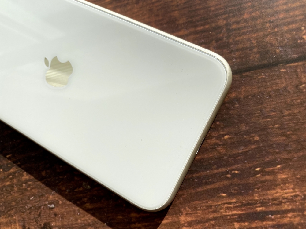 The underside of a white iPhone 11 on a table