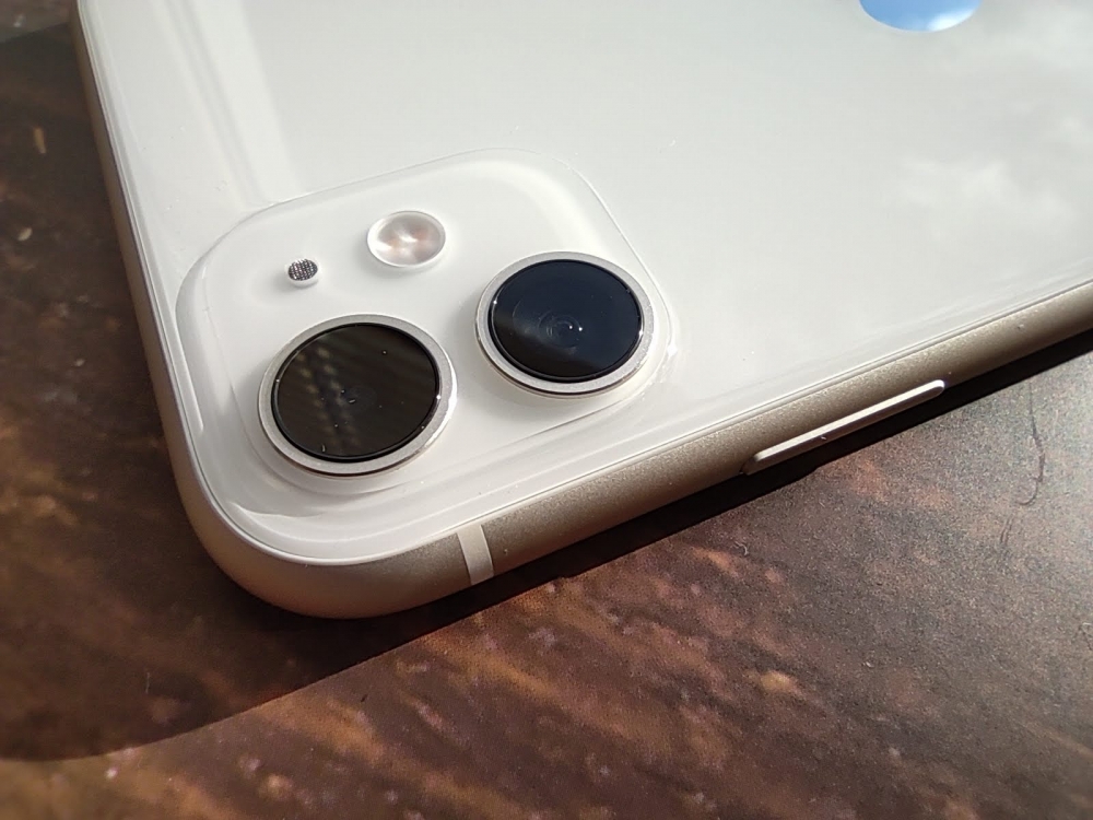 テーブルに置かれた白いiPhone 11のデュアルカメラ周辺